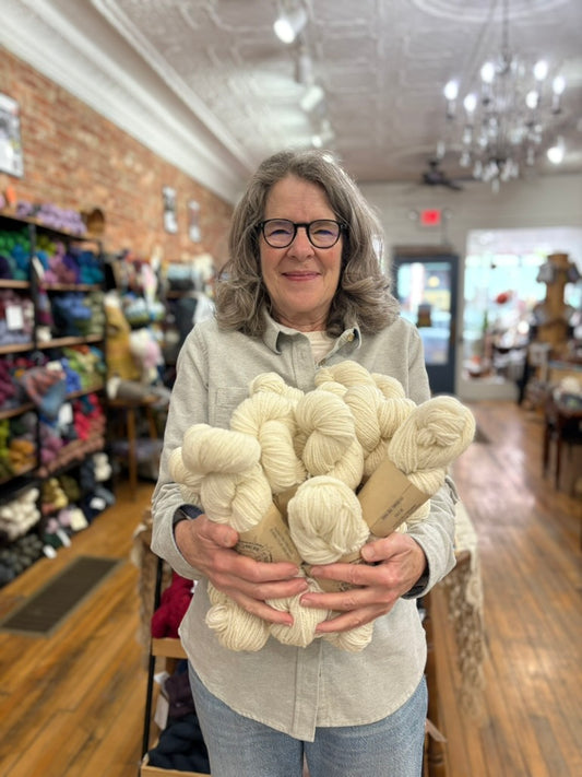 Woman holding skeins of yarn in a store setting