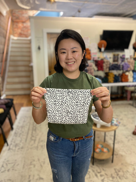 Person holding a black and white patterned fabric in a casual indoor setting